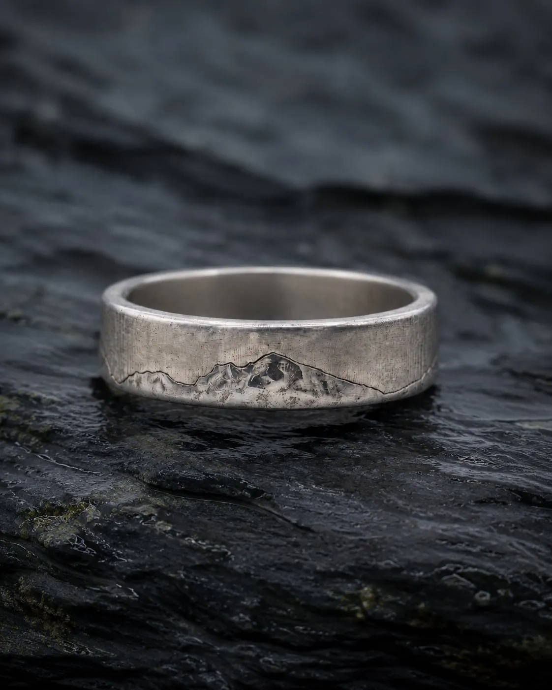 Welsh Three Peaks sterling silver ring on dark wet slate.